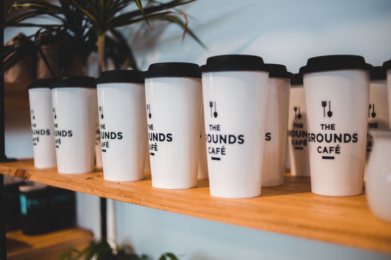 Mastering the First Impression: Your intriguing post title goes here Designed white for coffee with black silicone lids and cutlery symbols on shelf for sale in coffee shop