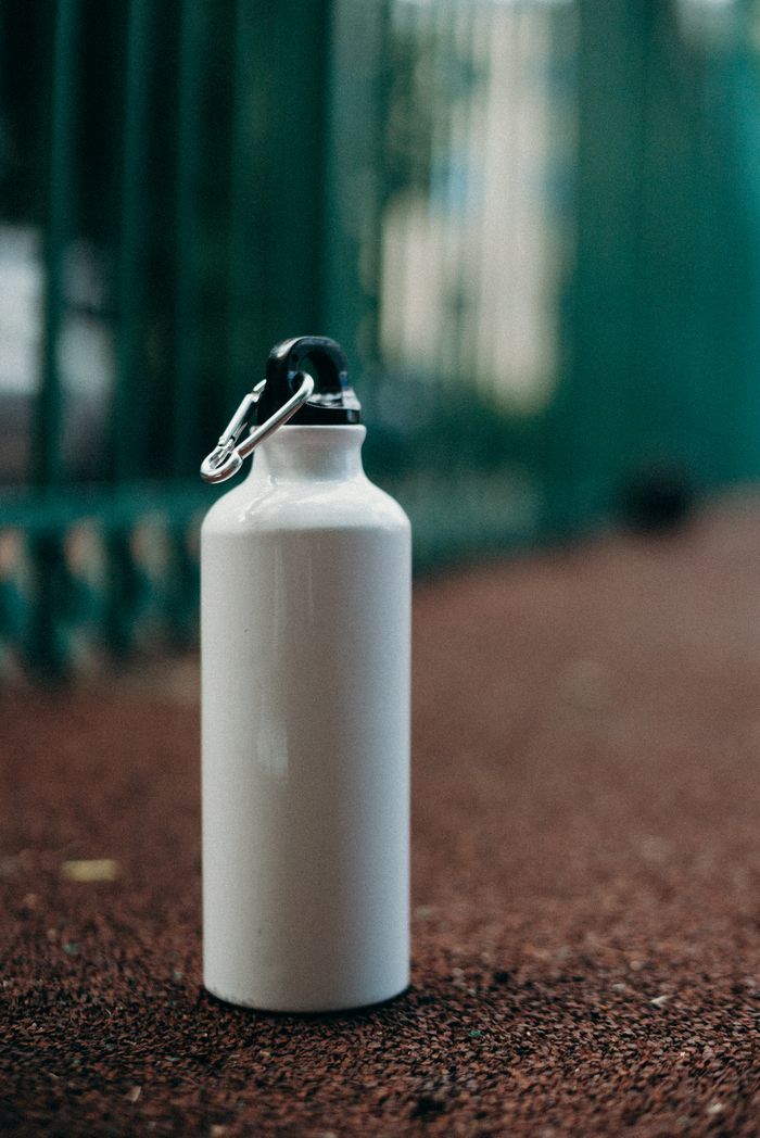 The Art of Drawing Readers In: Your attractive post title goes here White eco-friendly water bottle on a sports track promotes zero waste and sustainability.